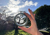 a jade bangle bracelet held up against a sunny sky.