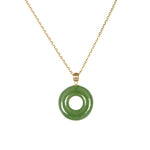A green donut-shaped nephrite jade pendant necklace with a 18k yellow gold bail and a gold-plated silver chain.