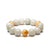 A bracelet featuring round beads in shades of white and yellow, representing a mix of jade and topaz.
