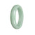 A light green jade bangle with a half moon design, made of authentic untreated jadeite jade.