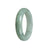 A half moon-shaped pale green Burma Jade bangle bracelet, showcasing its natural beauty and elegance.