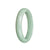 A light green jadeite bangle with a half moon design, measuring 59mm. Made from genuine grade A jadeite. Offered by MAYS GEMS.
