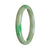 A close-up image of a genuine Type A Green Burma Jade bracelet. The bracelet is 64mm in size and has a semi-round shape. It is a beautiful piece of jewelry from the brand MAYS.