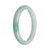 A close-up image of a traditional jade bangle in a beautiful apple green color with white streaks. The bangle is made of high-quality Grade A jade and has a semi-round shape. It measures 62mm in diameter. Designed by MAYS™.