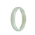 A close-up photo of a stunning jade bangle featuring a half moon shape. The bangle is made of high-quality, Grade A white Burmese jade, known for its exquisite beauty. The smooth, polished surface of the bangle reflects light, showcasing the natural variations and unique patterns of the jade. This luxurious piece of jewelry, measuring 56mm in diameter, is a testament to the skill and craftsmanship of MAYS™.