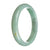 A close-up photo of an elegant light green jade bangle bracelet with a half-moon shape. The bracelet is made from Grade A authentic jadeite jade and measures 83mm in diameter. It is a beautifully crafted piece of jewelry by MAYS™.