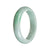 A close-up image of an Authentic Grade A Green on white Jade Bangle Bracelet. The bracelet is designed in a half-moon shape and measures 59mm in size. The vibrant green color of the jade stands out against the white backdrop, giving the bracelet an elegant and natural look. This bangle is a product of MAYS™.