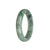 Close-up image of a beautiful jade bangle, featuring a half-moon shape. The jade is a stunning combination of green and grey, displaying its genuine grade A quality. Perfect for adding an elegant touch to any outfit.
