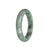 A half moon-shaped bangle bracelet made of genuine untreated green and grey Burma jade, showcasing its natural beauty.