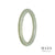 A pale green jadeite jade bangle with an oval shape, measuring 60mm in diameter. Expertly crafted and of the highest quality, this bangle is a stunning piece of jewelry by MAYS™.