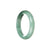 A close-up image of a bluish green Burmese jade bangle bracelet, showcasing its unique half moon shape. This high-quality bracelet is made of genuine Grade A jade, perfect for adding a touch of elegance to any outfit.
