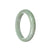 A half moon-shaped, untreated green jadeite bangle, measuring 59mm in size.