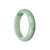 A half moon-shaped, pale green and emerald green jade bangle, certified as Type A.