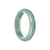 A close-up image of a green jadeite jade bracelet in the shape of a half moon, measuring 58mm in diameter. The bracelet features a smooth and polished surface, showcasing the natural beauty of the jade stone. The color of the jade is a vibrant green, with subtle variations and patterns running through it. The bracelet is designed to be worn on the wrist, adding an elegant and earthy touch to any outfit.