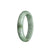 A half-moon shaped jade bracelet in green with white accents, showcasing traditional craftsmanship and natural beauty.