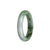 An exquisite bangle bracelet made of natural, untreated white Burmese jade with stunning green hues. The bracelet features a half-moon shape and measures 56mm in diameter. A luxurious piece from MAYS™.