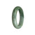 A high-quality, half-moon shaped, 57mm jade bangle made of authentic Grade A grey jade with mesmerizing green accents. Perfect for adding a touch of elegance to any outfit.