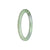 A small round jade bangle bracelet in light green with hints of white and lavender, untreated and sourced from Burma.