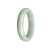 A half moon-shaped bangle bracelet made of genuine untreated white and pale green jadeite jade, measuring 59mm in size. Sold by MAYS.