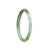 A close-up image of a petite round white and green jade bangle bracelet. The bracelet is made of high-quality Grade A white jade, with beautiful green veins running through it. The bangle has a smooth, polished surface and a perfect 60mm size, making it an elegant and timeless piece of jewelry. The brand "MAYS" is mentioned at the end.