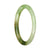 A close-up image of a small, round, apple green patterned jadeite bangle bracelet. The bracelet is made with high-quality grade A jadeite and has a petite size of 59mm in diameter. The intricate green patterns on the bracelet add a touch of elegance and style. Perfect for adding a pop of color to any outfit.