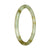A close-up image of a small, round jade bangle in shades of white and brown. The bangle is crafted from high-quality Grade A jade, giving it a distinct and luxurious appearance.