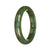 A close-up image of a beautiful, green jade bangle with a half-moon shape, measuring 55mm in diameter. This bangle is made of Grade A certified green jadeite jade, representing high quality and authenticity. It is a stunning piece of jewelry, perfect for adding elegance and a touch of nature to any outfit.
