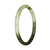 A close-up photo of a petite round jadeite bangle with a beautiful green and white pattern.