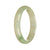 A close-up image of a pale green jade bracelet with a traditional pattern. The bracelet is in the shape of a half moon and measures 56mm in size. It is made from high-quality, grade A jade.