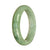 A light green traditional jade bracelet with a half moon pattern.