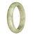 A close-up photo of a half moon-shaped grey patterned Burmese jade bangle, measuring 63mm in size.