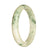 A close-up photo of a jadeite bangle bracelet, featuring a white and greyish green pattern. The bracelet is shaped like a half moon with a diameter of 65mm. It is a genuine grade A jadeite piece from MAYS GEMS.