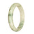 A close-up photo of an untreated white and greyish green pattern jadeite bangle with a half moon shape, measuring 65mm.