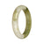 A close-up photo of an elegant jade bangle with a half-moon shape, crafted from authentic Grade A White and Olive Green Burmese Jade. The bangle measures 54mm in diameter and features a smooth and polished surface. The jade has a beautiful combination of white and olive green hues, creating a stunning contrast. Designed by MAYS™, this bangle is a timeless piece of jewelry.