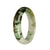 A beautiful half-moon shaped Burmese jade bangle with a white and green pattern.