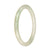 A close-up image of a petite round pale green jade bangle, known as a Type A Jade. The bangle has a smooth and glossy surface, showcasing the natural beauty of the jade. It measures 60mm in diameter and is crafted with genuine jade, making it a high-quality piece. The bangle is designed by MAYS, a reputable brand known for their exquisite jade jewelry.