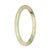 A close-up photo of a small, round Burmese jade bangle in a vibrant light green color. The surface of the bangle is adorned with a delicate pattern, showcasing the high quality and craftsmanship. It measures 60mm in diameter and is certified as Grade A jade. Perfect for those who love petite and elegant jewelry pieces. From the MAYS™ collection.