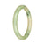 A small, round light green jade bangle bracelet, certified as Grade A quality. Perfect for adding a touch of elegance to any outfit.