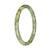 A close-up image of a small round jade bangle bracelet with a beautiful green and brown pattern.