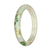 A beautiful pale green jade bangle bracelet with a green pattern, shaped like a half moon.