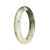 A half-moon shaped white and green jade bangle bracelet, untreated and authentic, measuring 57mm in size.