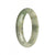 A half moon shaped Burma Jade bangle bracelet with a natural white color and green pattern.