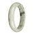 A pale green jade bangle bracelet with a dark green pattern, brown spots, and a half moon shape, available in size 67mm.