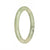 A small round jade bangle bracelet with green and white colors, adorned with dark green spots.