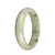 A beautiful pale green and white jade bangle featuring dark green patterns, in a half moon shape, measuring 59mm.