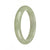 A close-up image of a beautiful jade bangle bracelet with a half-moon shape. The jade is certified as Grade A and is a vibrant green color. The bracelet has a smooth and polished surface, showcasing the natural beauty of the stone. Designed by MAYS™.