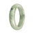 A beautiful jade bangle bracelet featuring a mix of green and lavender tones with apple green spots, crafted from genuine Grade A jade. The bracelet has a 57mm diameter and a unique half moon shape. A stunning piece from MAYS GEMS.
