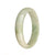 A stunning traditional jade bangle in white with apple green patterns, featuring a half moon shape. A beautiful and authentic piece from MAYS GEMS.