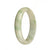 A half moon-shaped Burmese Jade bangle featuring a genuine, natural white color with beautiful apple green patterns.
