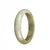 An authentic half moon-shaped pale green and brown jade bangle, measuring 54mm.